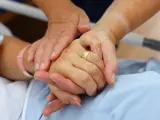 Close up of a nurse holding patient hand showing compassion