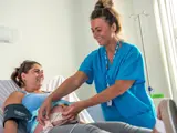 Smiling female midwife checking baby bump